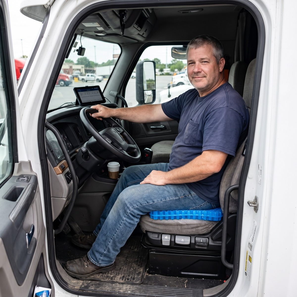 Truck driver sitting on the Wovaire Gel+ cushion in the driver's seat of his semi